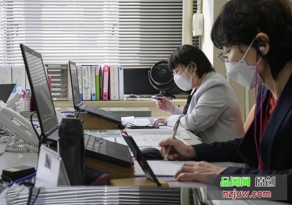 Staffers operate a Nagoya-run phone co<em></em>nsultation service, which opened last week, for people experiencing side effects after receiving a COVID-19 vaccine. | POOL / VIA KYODO