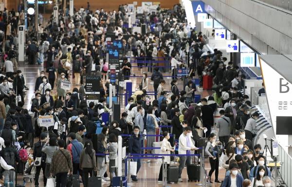 Tokyo's Haneda Airport is crowded with travelers on Friday.  | KYODO